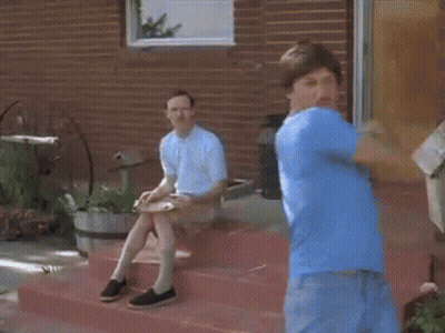 Man in Blue Shirt Standing on Steps With Sitting Man