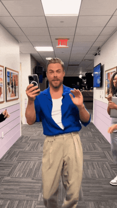 Man In Blue Shirt Taking Selfie Under Exit Sign GIF