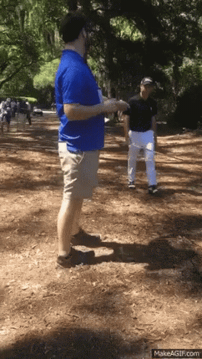 Man In Blue Shirt Talking On Dirt Path GIF