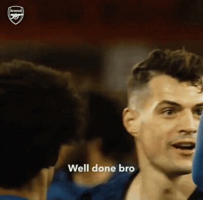 Man In Blue Shirt Talking To Another In Crowd GIF