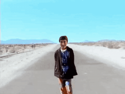 Man In Blue Shirt Walking Desert Road GIF
