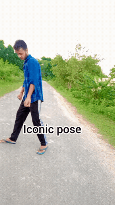 Man in Blue Shirt Walking Down Road Saying Iconic Pose