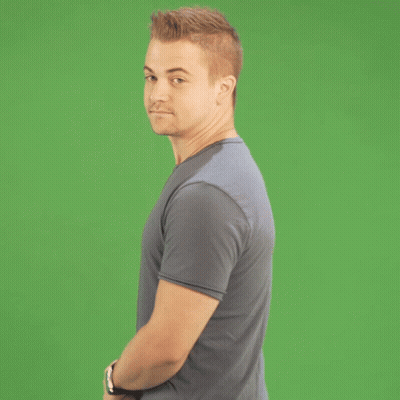 Man In Blue Shirt Waving In Front Of Green Screen GIF
