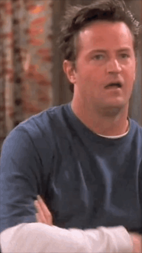 Man In Blue Shirt With Arms Crossed Making Funny Face GIF