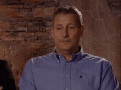 Man In Blue Shirt With Black Embroidered Logo GIF