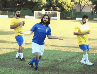 Man In Blue Shirt With Brazilian Flag Dancing On Soccer Field GIF