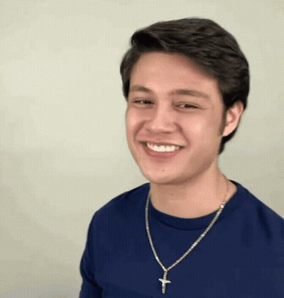 Man In Blue Shirt With Cross Necklace Smiling GIF
