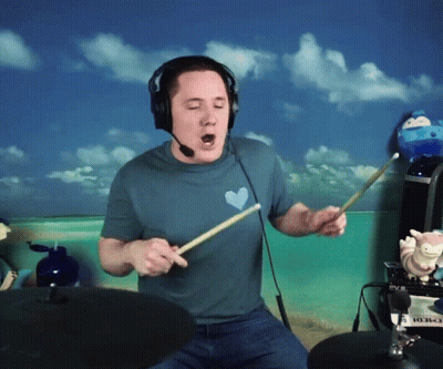 Man in Blue Shirt With Heart Playing Drums