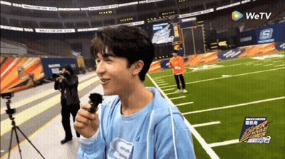 Man In Blue Shirt With Letter S Holding Microphone GIF