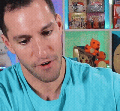 Man In Blue Shirt With Shelf Of Pokemon Toys GIF