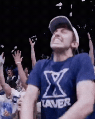 Man In Blue Shirt With X Dancing In Crowd GIF