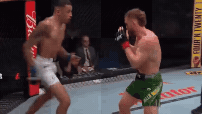 Man In Blue Shorts In Front Of UFC Sign GIF
