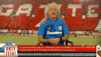 Man In Blue Stoiximan Shirt Sitting In Front Of Crowd GIF