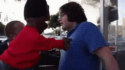 Man In Blue Striped Shirt Talking To Man In Red Sweater GIF