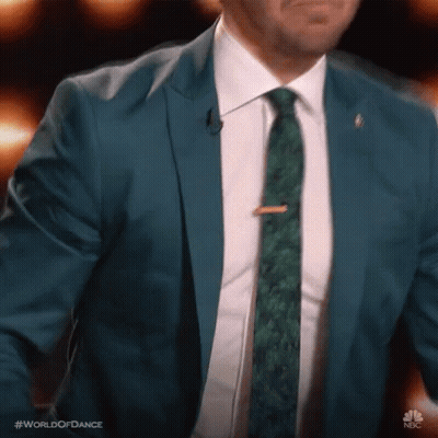 Man In Blue Suit And Green Tie At Microphone GIF