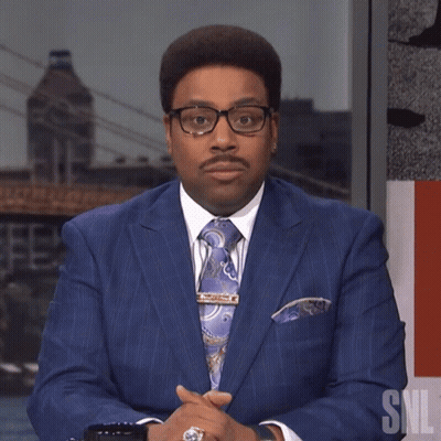 Man In Blue Suit And Tie Beside SNL Logo GIF