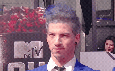 Man In Blue Suit And Tie In Front Of MTV Logo GIF
