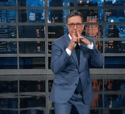 Man In Blue Suit And Tie Shushing GIF