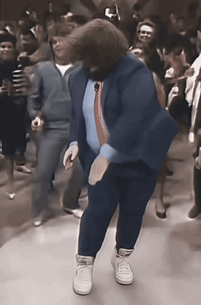 Man in Blue Suit Dancing in Front of Crowd