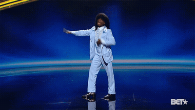 Man In Blue Suit Dancing On Stage With BET Logo GIF