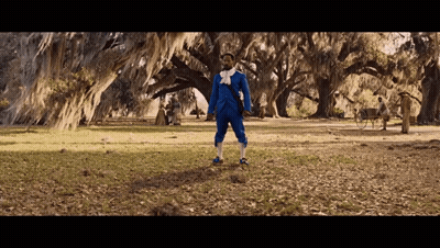 Man In Blue Suit In Field With Trees GIF