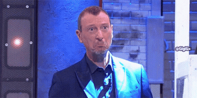 Man In Blue Suit Making Funny Face In Front Of Brick Wall GIF