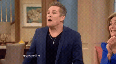 Man In Blue Suit Standing In Front Of Woman And Meredith Sign GIF