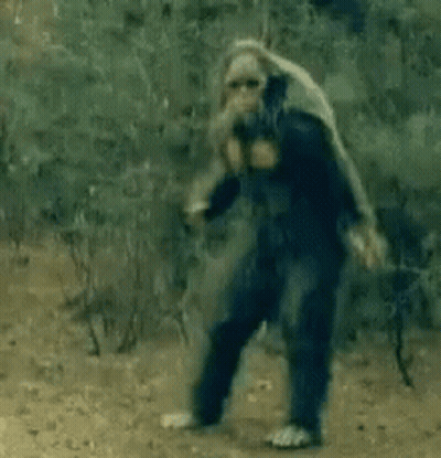 Man In Blue Suit Standing On Dirt Road GIF