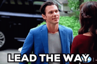 Man In Blue Suit Talks To Woman Saying Lead The Way GIF