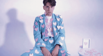 Man In Blue Suit With Hearts GIF