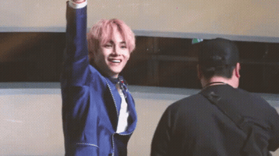 Man In Blue Suit With Pink Hair Raising Arm GIF