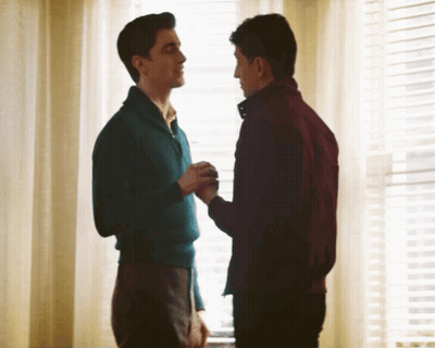Man In Blue Sweater Holding Hand Of Man In Red Jacket GIF