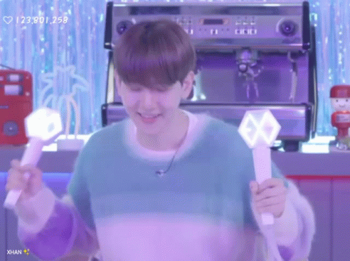 Man In Blue Sweater Holding Light Stick With Exo Logo GIF