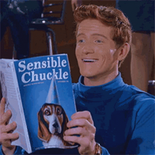 Man In Blue Sweater Reading Book Sensible Chuckle GIF