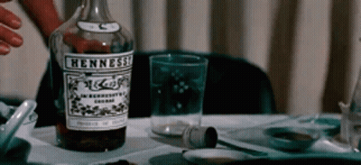 Man In Blue Sweater Sitting At Table With Wine Bottle GIF