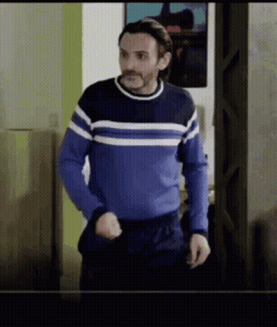 Man In Blue Sweater Standing In Doorway GIF