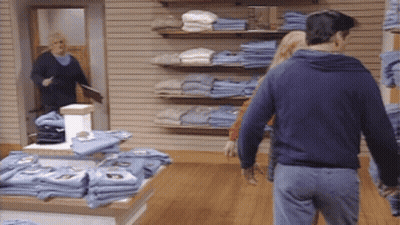 Man In Blue Sweatshirt Walking Through Store GIF