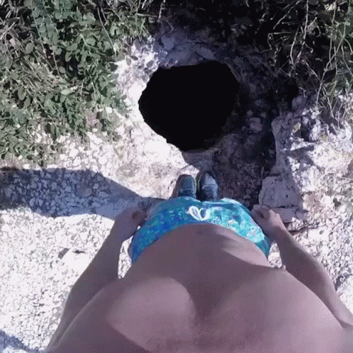Man In Blue Swim Trunks Standing In Front Of Hole GIF