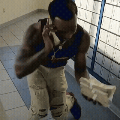 Man In Blue Tank Top Talking On Phone Holding Money GIF