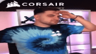 Man In Blue Tie Dye Shirt In Front Of Corsair Logo GIF