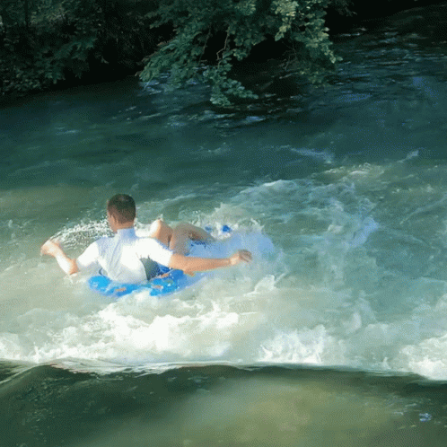 Man In Blue Tube Floating Down River GIF