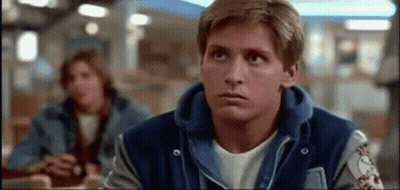 Man In Blue Varsity Jacket Sitting At Restaurant Looking Up GIF