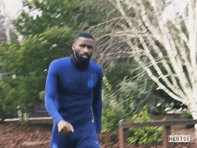 Man In Blue Wetsuit Walking Past Heitse Sign GIF