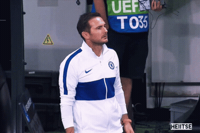 Man In Blue White Nike Jacket In Front Of Man In Green Vest Saying UEF T035 GIF
