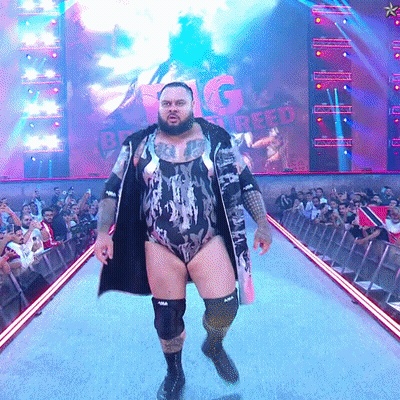 Man In Bodysuit Walking Runway With Big Creed Screen GIF