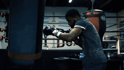 Man In Boxing Gloves Standing In Front Of Mack Bag GIF