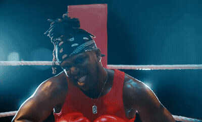 Man In Boxing Ring With Red Gloves And X Necklace GIF