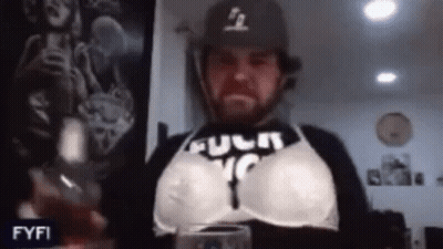 Man In Bra And Baseball Cap Holding Wine GIF