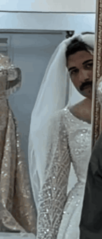 Man In Bride's Dress Looking In Mirror GIF