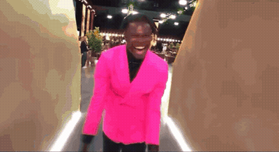 Man In Bright Pink Suit Walking Down Hallway GIF